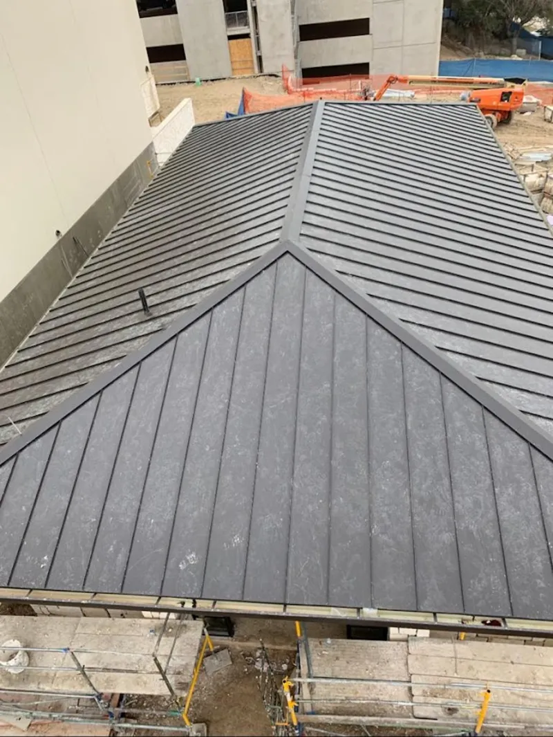 Commercial metal roof construction with crane equipment in Livermore